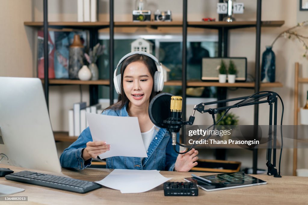 Woman working on radio station, talking on microphone in talk show