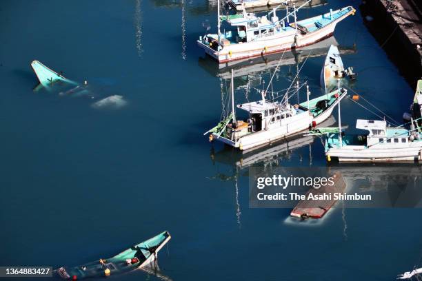 In this aerial image, some fish boats are sunk and overturned after tsunami on January 16, 2022 in Muroto, Kochi, Japan. No casualties have been...