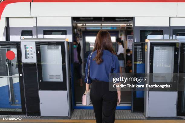 lifestyle business woman using phone and tablet at urban street and train station. - bts skytrain stock pictures, royalty-free photos & images