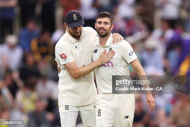 Chris Woakes of England congratulates Mark Wood of England after he took the wicket of Pat Cummins of Australia during day three of the Fifth Test in...