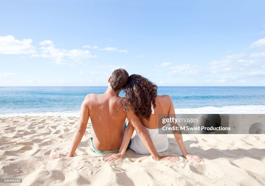 Couplesiting in beach in sunlight