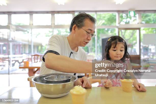 father and child doing homemade ice cream - filipino family eating stock-fotos und bilder