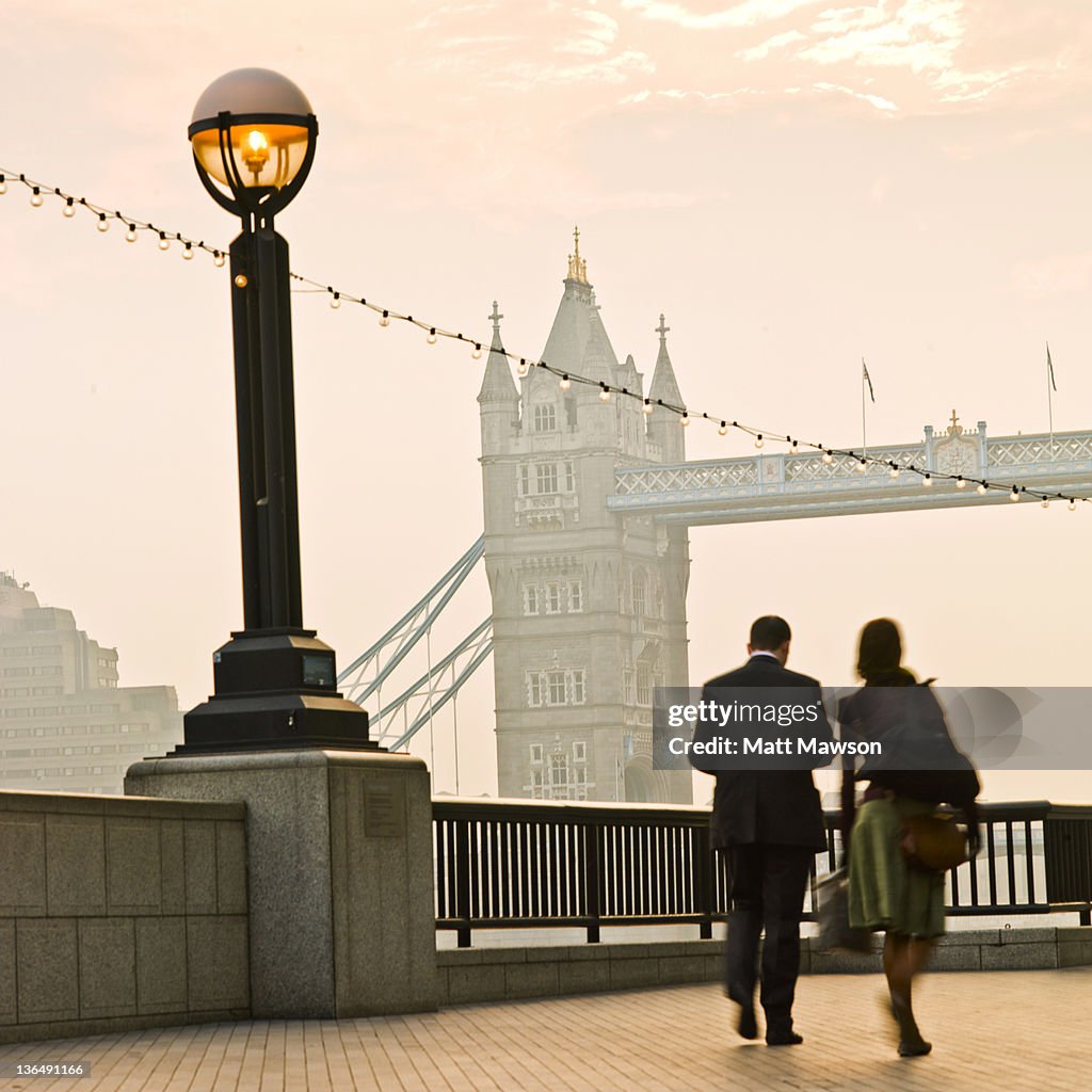 Man and woman walking by Tower Bridge