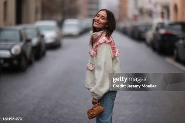 Anna Schürrle wearing beige and baby pink Sidney New York jacket, brown leather pouch, and blue Agolde jeans on January 13, 2022 in Berlin, Germany.