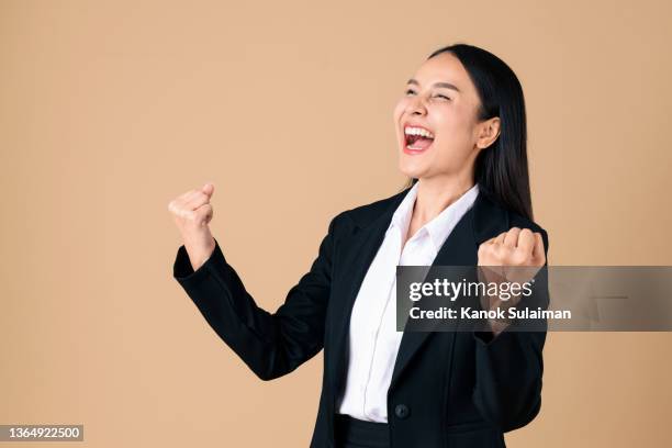 studio shot of cheering businesswoman with arms raised into fists celebrating good news - screaming man looking up stock-fotos und bilder