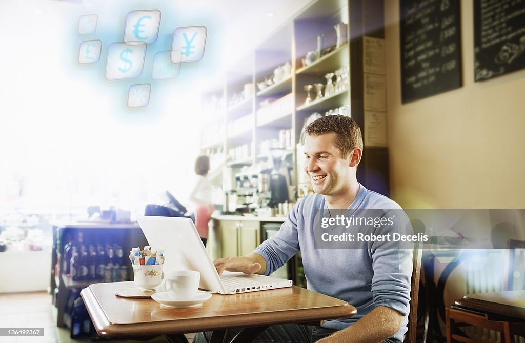 Man using laptop in cafe