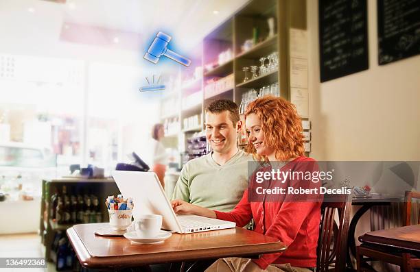 couple following online auction on laptop - newfriendship stock pictures, royalty-free photos & images