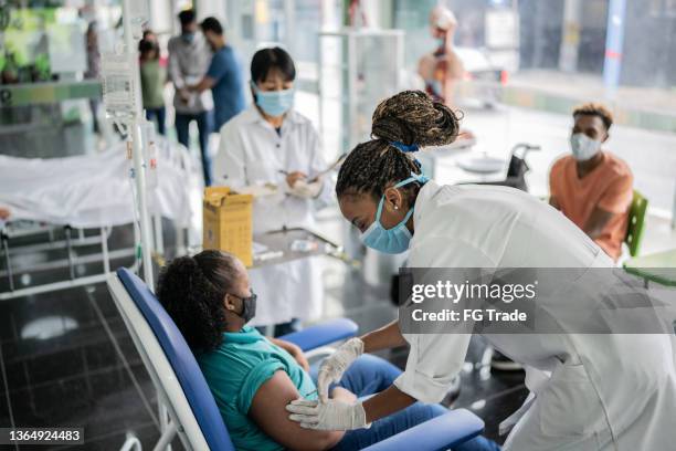 jovem com necessidades especiais é vacinada em clínica médica - epidemiologia - fotografias e filmes do acervo