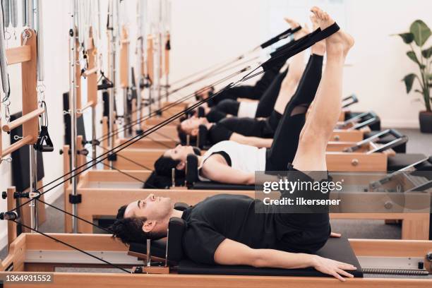 man doing pilates in studio - pilates equipment stock pictures, royalty-free photos & images