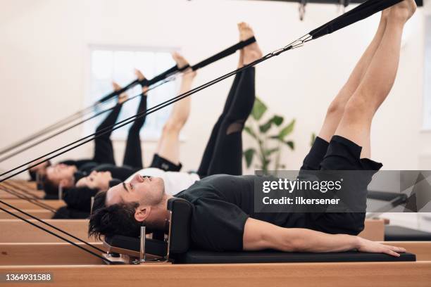 mann macht pilates im studio - pilates gerät stock-fotos und bilder