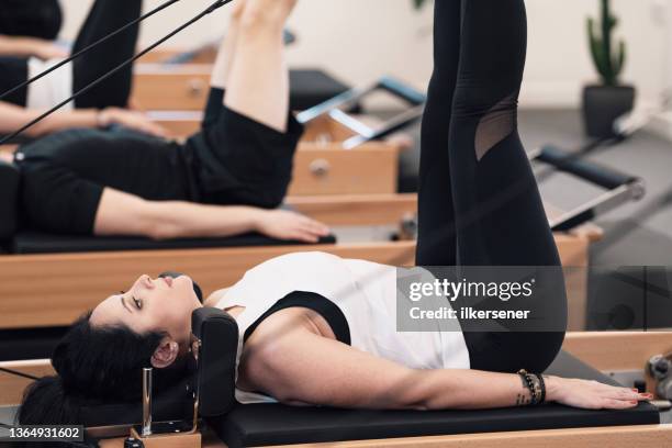 woman doing pilates in studio - reformer stock pictures, royalty-free photos & images