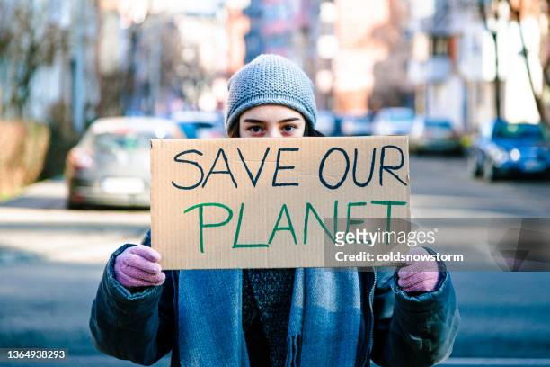 un jeune militant tenant une pancarte pour protester contre le changement climatique - parade militaire photos et images de collection