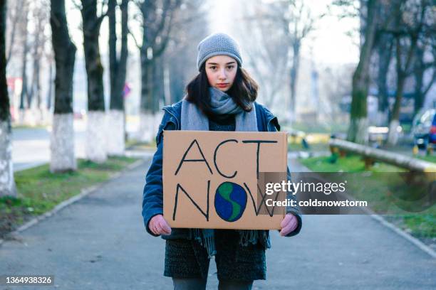 junge aktivistin hält schild gegen klimawandel - demonstrieren stock-fotos und bilder