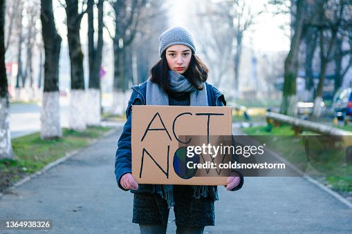 Young activist holding sign protesting against climate change Young activist holding sign protesting against climate change