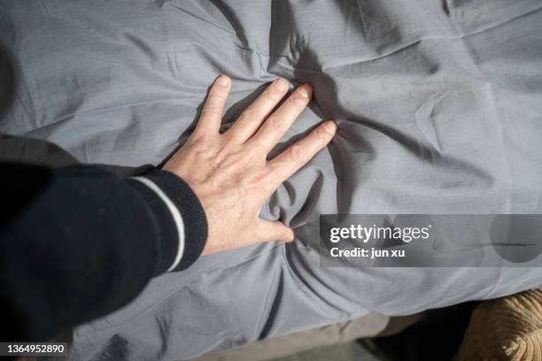 soft grey quilt in her hand - acaro foto e immagini stock