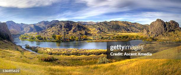 wide shot of missouri river flowing past mtns - missouri river stock pictures, royalty-free photos & images