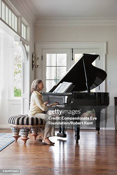senior woman playing piano - grand piano stock pictures, royalty-free photos & images