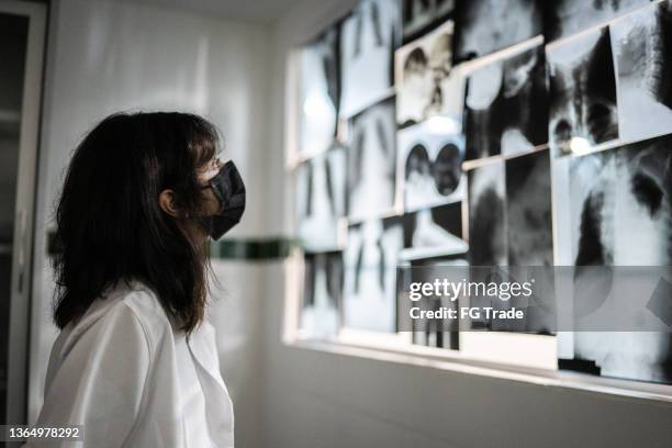 teenage girl looking at x-rays - using a face mask - hospital reopening stock pictures, royalty-free photos & images