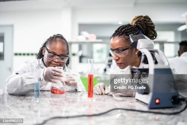 teacher teaching a student with special needs in the laboratory - biochemist stock pictures, royalty-free photos & images