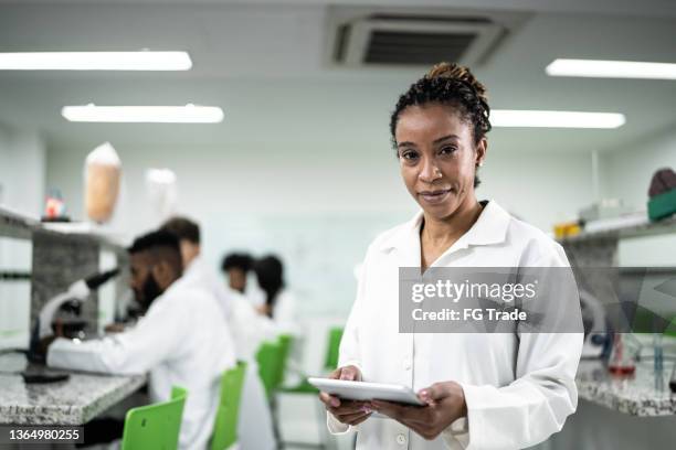 retrato de uma mulher madura usando um tablet digital em laboratório - bioquímica - fotografias e filmes do acervo