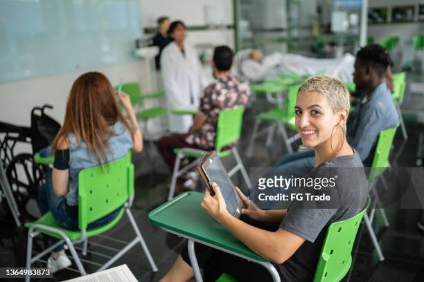 retrato de uma jovem feliz usando tablet digital na sala de aula - skinhead girls - fotografias e filmes do acervo