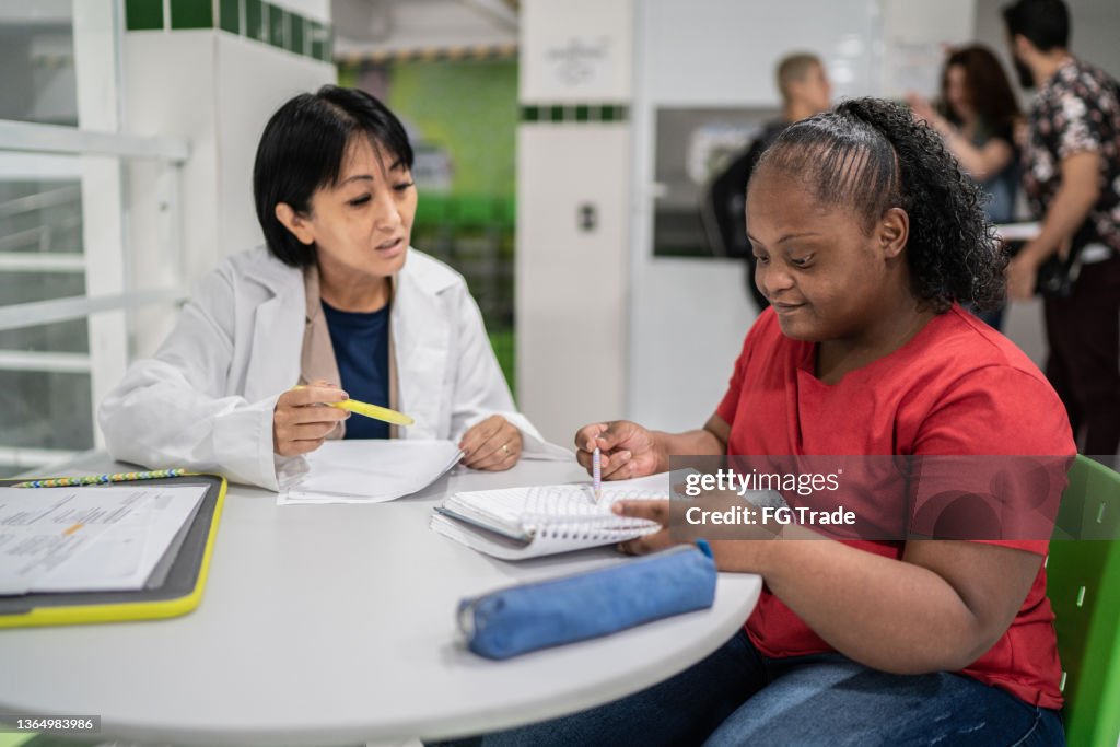 Teacher helping special needs student at school