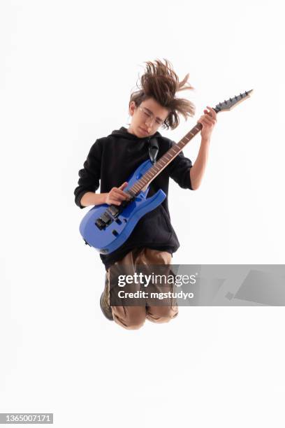 bel ragazzo che suona una chitarra elettrica e salta - plucking an instrument foto e immagini stock