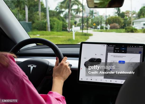 cockpit with lcd touch screen of electric car tesla model y during drive. - auto interieur stockfoto's en -beelden