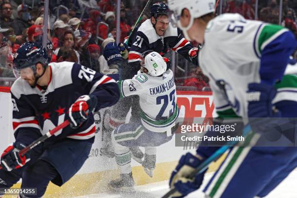 Garnet Hathaway of the Washington Capitals checks Oliver Ekman-Larsson of the Vancouver Canucks during the second period at Capital One Arena on...