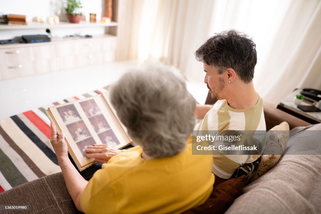 Man and his senior mom looking through family photos together
