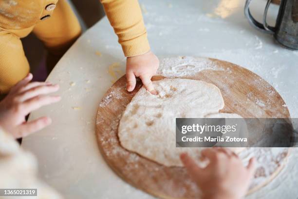 family education, a child in the kitchen playing with dough and flour - heart shape pizza stock pictures, royalty-free photos & images