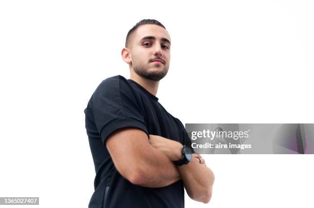 close up of young model wearing a black shirt and posing for the camera crossed arms - low angle view imagens e fotografias de stock