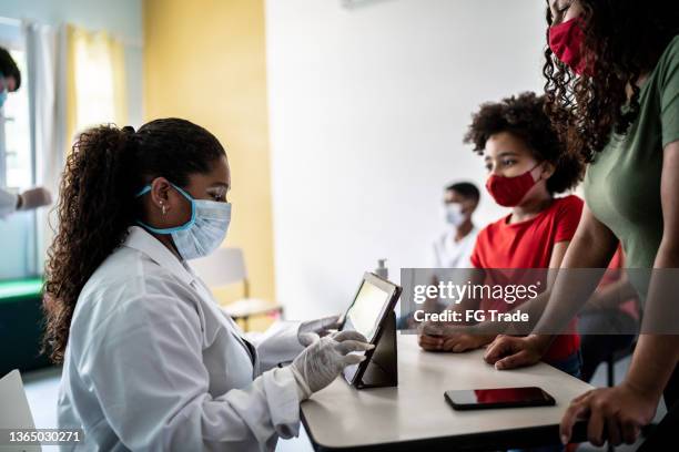 mother and daughter entering on a vaccination center - vaccination center stock pictures, royalty-free photos & images