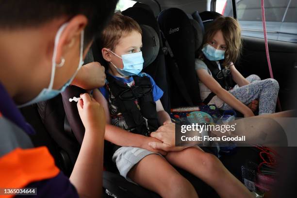 Hugo Hawkey is vaccinated as his sister Florence looks on at the drive-through vaccination centre at North Shore Events Centre on January 17, 2022 in...