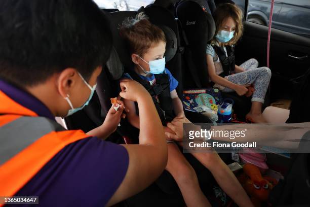 Hugo Hawkey is vaccinated as his sister Florence looks on at the drive-through vaccination centre at North Shore Events Centre on January 17, 2022 in...