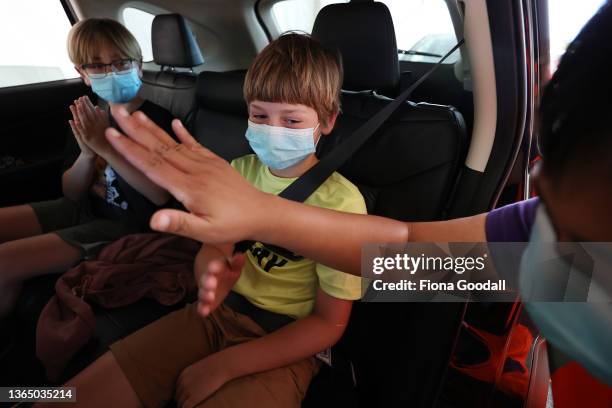 Eddie Vanderbom high fives the nurse after his vaccination as his brother Alex looks on at the drive-through vaccination centre at North Shore Events...