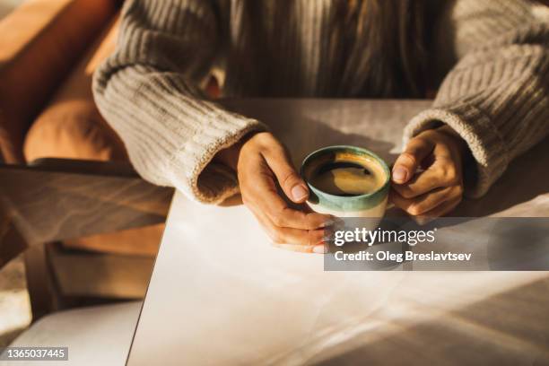 woman hands holding coffee cup on table. beautiful sun light and room for copy space - coffee cups table stock pictures, royalty-free photos & images