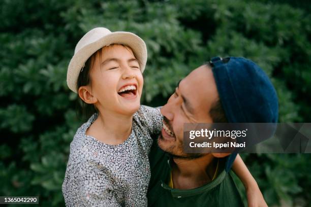 cheerful father and young daughter embracing - familia de dos generaciones fotografías e imágenes de stock