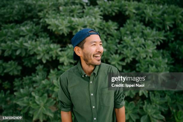 portrait of cheerful japanese man with cap - beautiful 40 year old man stock pictures, royalty-free photos & images
