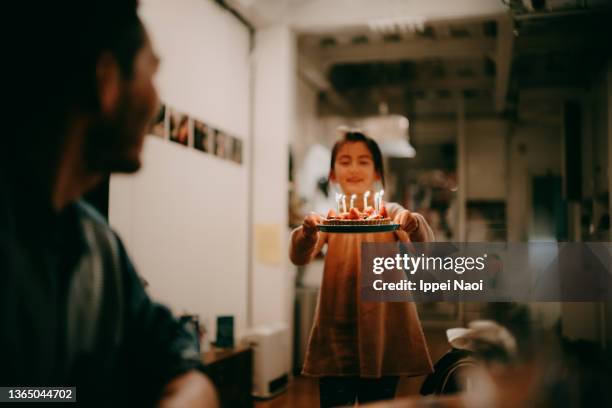 girl bringing birthday cake to her father at home - daughter birthday stock pictures, royalty-free photos & images