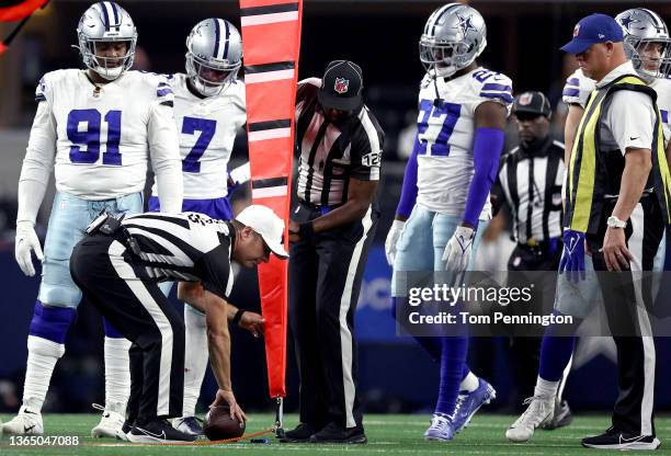 Referees measure the ball on fourth and inches during the fourth quarter of a game between the Dallas Cowboys and San Francisco 49ers in the NFC Wild...