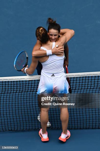 Maria Sakkari of Greece embraces Tatjana Maria of Germany after winning her first round singles match during day one of the 2022 Australian Open at...