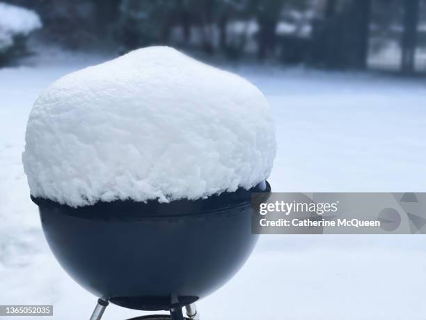 outdoor charcoal grill topped with mound of fresh snow - schneehaufen stock-fotos und bilder