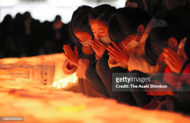 People light candles in commemoration of the victims a night before the 27th anniversary of the Great Hanshin Earthquake on January 16, 2022 in Kobe,...