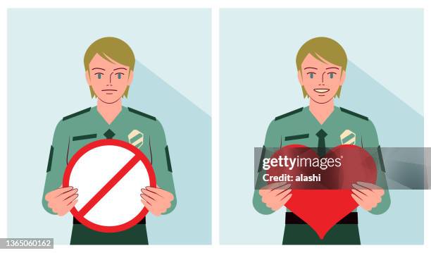 ein junger polizist hält ein herzformschild und ein verbotsschild in der hand - caucasian appearance stock-grafiken, -clipart, -cartoons und -symbole