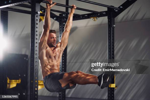 junger mann macht l-sit übung im freien - reck stock-fotos und bilder
