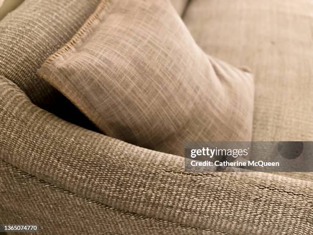 side profile view of textured gray sofa with decorative throw pillow - capitonné photos et images de collection