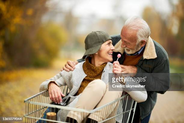joven de corazón pareja de ancianos hablando en el parque. - lollipop fotografías e imágenes de stock