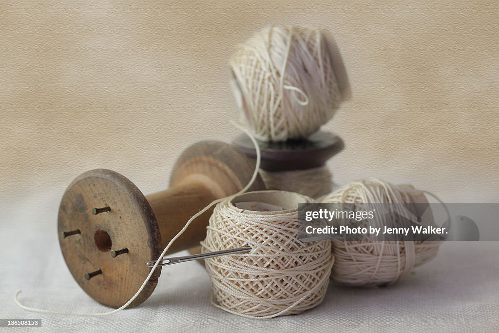 Sewing cottons and empty wooden cotton reel