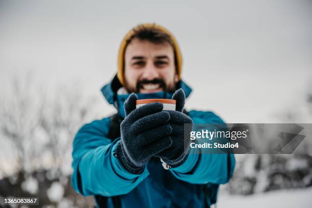 heißer tee beim winterwandern ist das beste - skijacke stock-fotos und bilder
